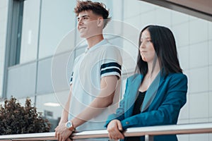 Caucasian young boy and girl looking from a fence outside of the building