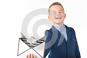 Caucasian young boy holds gift box similar like a mail letter or present for christmas.The boy closed his eyes