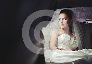 Caucasian young bride sitting in limo.