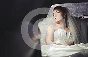 Caucasian young bride sitting in limo.