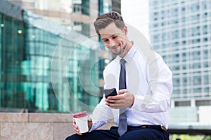 Caucasian young businessman with coffee and mobile phone at hong