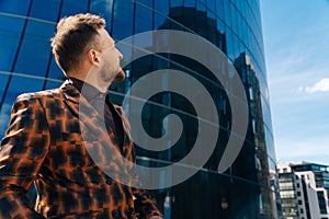 Caucasian young businessman looks to the side of the thinking. The concept of a business man on the street