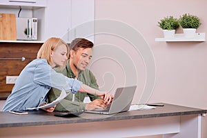 Caucasian young couple reading and analyzing bills sitting at table