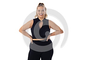 Caucasian young female plus size model on white background, hands on hips, smiling, copy space