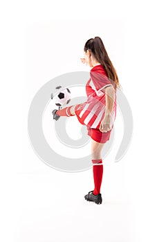 Caucasian young female soccer player kicking soccer ball against white background with copy space