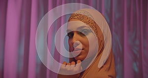 Caucasian young girl in hijab neon orange color pink background portrait makeup
