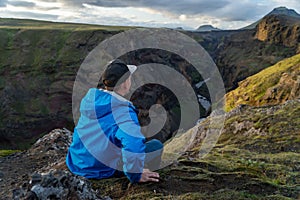 Caucasian young guy standing in over mountain and canyon background on the way of Laugavegur trail, Iceland. Promoting