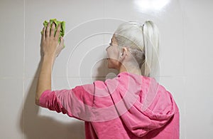 A caucasian young housemaid cleaning a bathroom