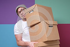 Caucasian young man carrying paper box moving to new office