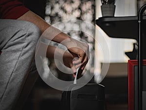 A caucasian young man is destroying documents in a black shredder