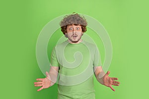 Caucasian young man`s monochrome portrait on green studio background