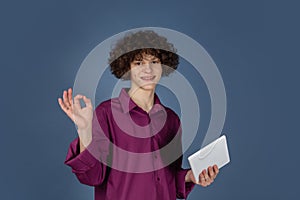 Caucasian young man's portrait isolated on blue studio background with copyspace