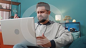 Caucasian young man use laptop surprised by bad news, fortune loss, fail, lottery results at home