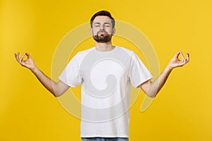 Caucasian young man white t-shirt standing isolated on gray studio background, folding fingers breath exercises process