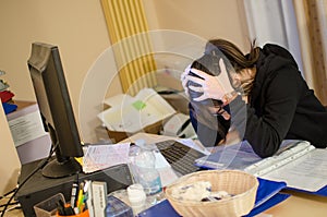 Stressed woman at work with computer in front of her photo