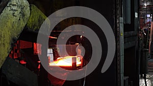 Caucasian young strong blacksmith working with open fire in furnace. The blacksmith forging hot iron workshop. Red hot
