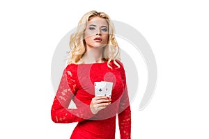 Caucasian young woman with long light blonde hair in evening outfit holding playing cards. Isolated. Poker