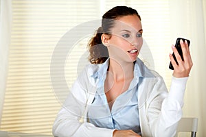 Caucasian young woman reading on cellphone