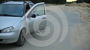 Caucasian young woman with red hair out of the car. the car broke. girl upset