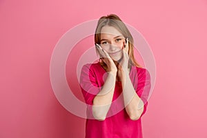 Caucasian young woman`s monochrome portrait on pink studio background, emotinal and beautiful