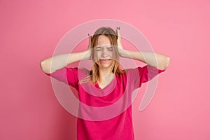 Caucasian young woman`s monochrome portrait on pink studio background, emotinal and beautiful