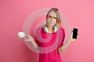 Caucasian young woman`s monochrome portrait on pink studio background, emotinal and beautiful