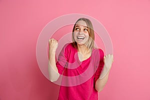 Caucasian young woman`s monochrome portrait on pink studio background, emotinal and beautiful