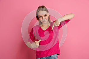 Caucasian young woman`s monochrome portrait on pink studio background, emotinal and beautiful