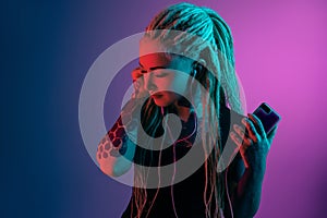 Caucasian young woman`s portrait on gradient background in neon light