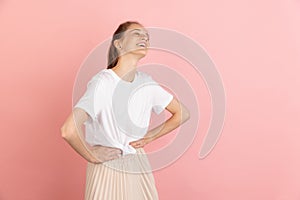 Caucasian young woman& x27;s portrait isolated over pink studio background with copyspace