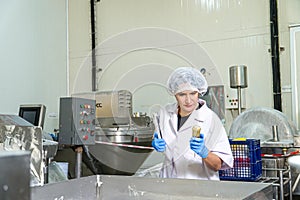 caucasion woman working in a food factory wearing protective clothes and gloves