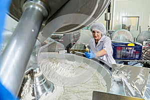 caucasion woman working in a food factory wearing protective clothes and gloves