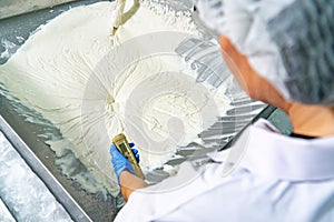 caucasion woman working in a food factory wearing protective clothes and gloves