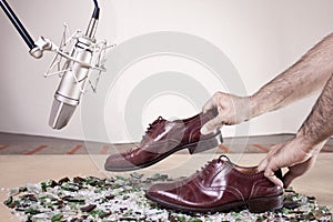 Caucassian male hands with male dress shoes moving on broken glass and near to a studio mic on Full Color Version