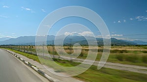 Caucasus Mountains on horizon seen from auto driving highway, travel by car