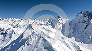 Caucasus Mountains, Panoramic view of the ski slope with the mountains Belalakaya, Sofrudzhu and Sulakhat on the horizon in winter