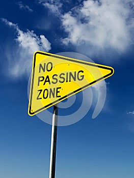 Cauction sign No passing zone sign with a blue sky background