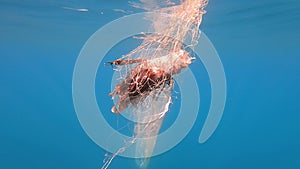 Caught Fish in Net Hanging From Boat Under Sea