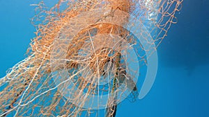 Caught Fish in Net Hanging From Boat Under Sea