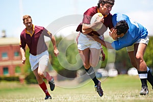 Caught mid-action. Full length shot of a young rugby player trying to avoid a tackle.