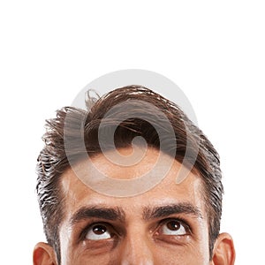 Caught up in his thoughts. Cropped image of a handsome young man looking up at copyspace against a white background.