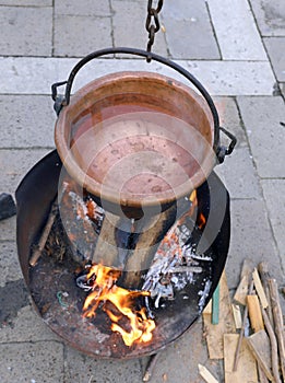 cauldron with boiling water and a large wood fire