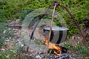 Cauldron or camping kettle over open fire outdoors