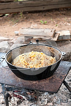 Cauldron with finished pilaff with a rice, carrot and mutton meat. Rice pilaf series, vertical image photo