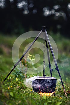 Cauldron with food and steam over fire