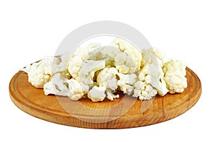 Cauliflower pieces on wooden cutting board isolated on white