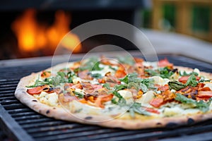 cauliflower pizza in a wood-fired oven with flames at the back