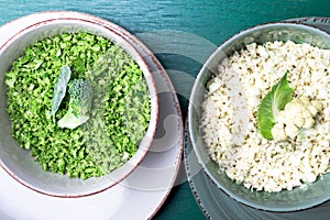Cauliflower rice and broccoli rice in bowl on green background. Top view. Overhead. Copy space. Shredded.