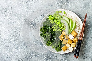 Cauliflower rice Buddha bowl with massaged kale, tofu, avocado and edamame beans. Vegan poke bowl.