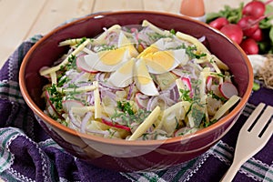 Cauliflower salad with potatoes, hard cheese, eggs, red onion and radish